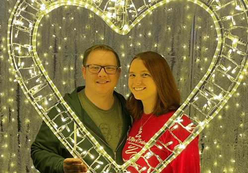 Jenny G and partner behind gold heart